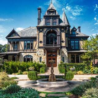 Large ornate house with a fountain in front on a sunny day at Beringer Winery