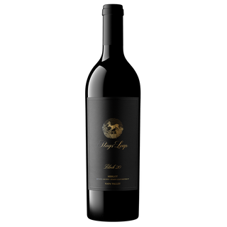 A bottle of Block 20 Merlot wine with a black label featuring gold and white text, set against a dark background.